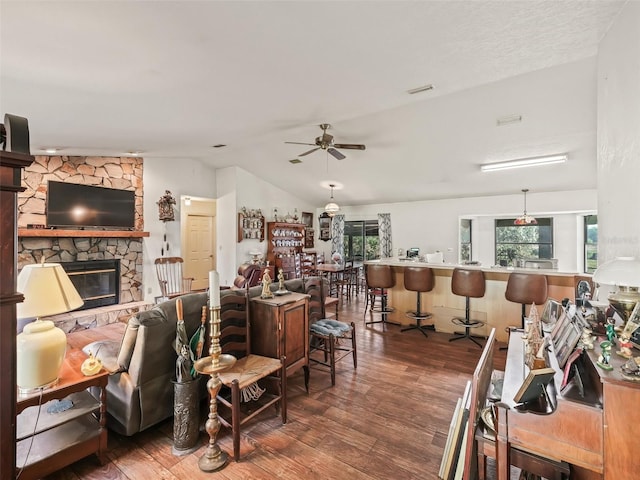 living room featuring lofted ceiling, ceiling fan, a fireplace, and wood finished floors