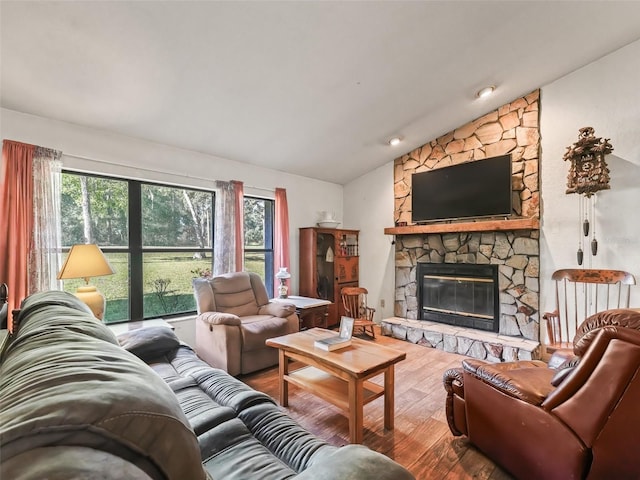 living room featuring lofted ceiling, a fireplace, wood finished floors, and a wealth of natural light