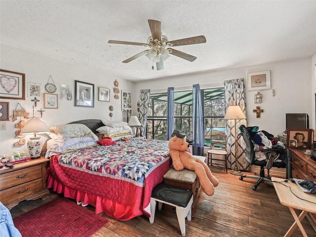 bedroom with a ceiling fan, a textured ceiling, and wood finished floors