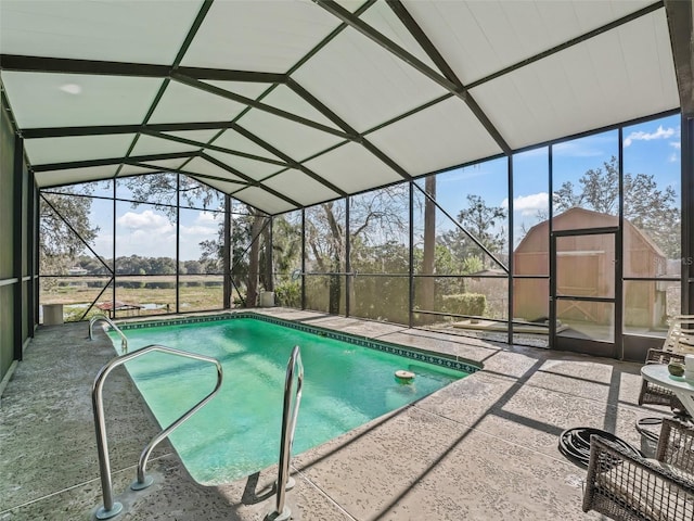 pool with a lanai, a patio area, a storage shed, and an outdoor structure