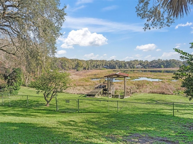 view of yard featuring a water view, fence, and a rural view