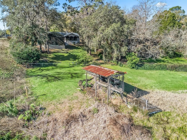 view of property's community featuring a lawn and an outdoor structure