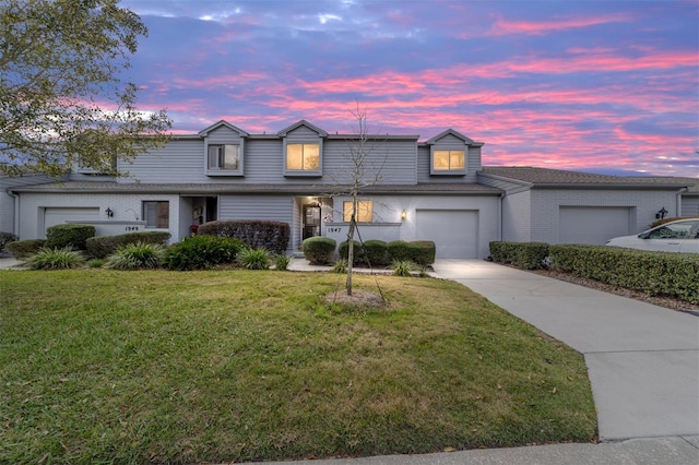 traditional home featuring driveway, brick siding, and a lawn