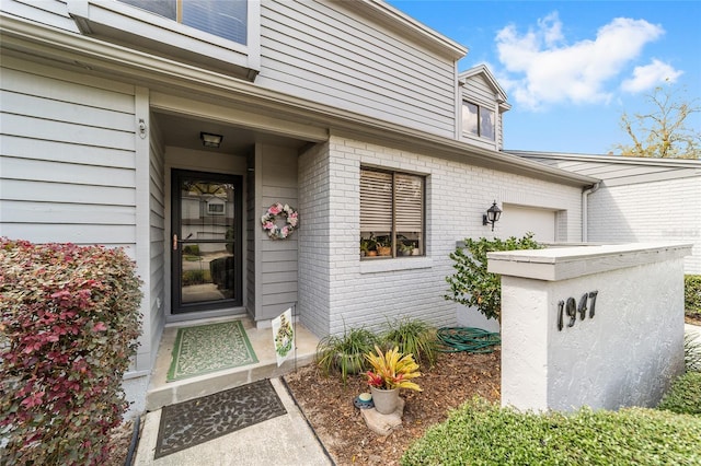 doorway to property with brick siding