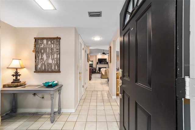 entryway with light tile patterned floors, ceiling fan, visible vents, and baseboards