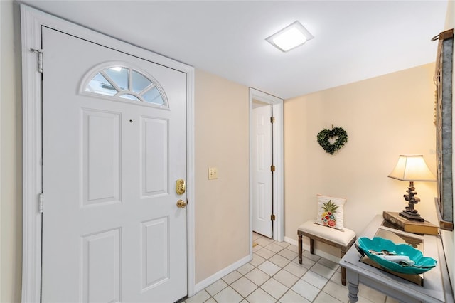 foyer entrance with light tile patterned floors and baseboards