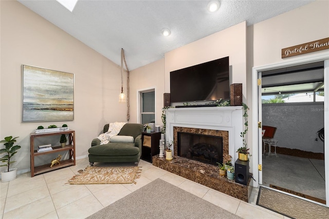 living area with vaulted ceiling, tile patterned flooring, a high end fireplace, and baseboards