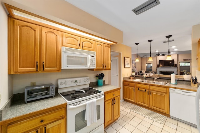 kitchen featuring white appliances, a toaster, visible vents, a fireplace, and a sink