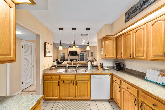 kitchen with dishwasher, light countertops, a fireplace, pendant lighting, and a sink