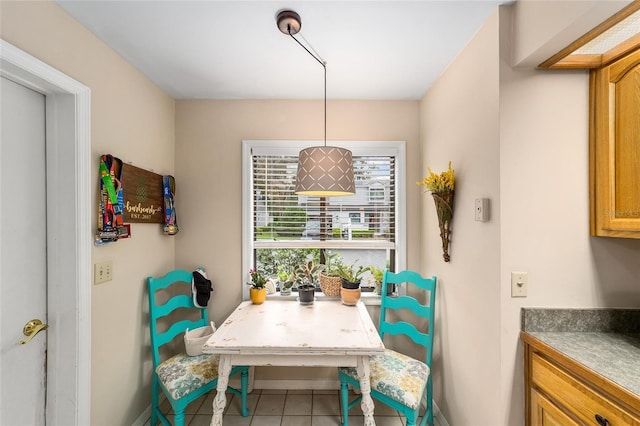 tiled dining room featuring baseboards