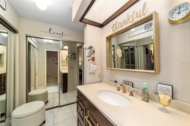 bathroom with vanity, a textured ceiling, and tile patterned floors