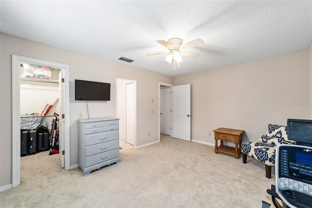 interior space with baseboards, visible vents, a ceiling fan, light colored carpet, and a textured ceiling