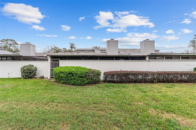 rear view of property with a lawn and a chimney