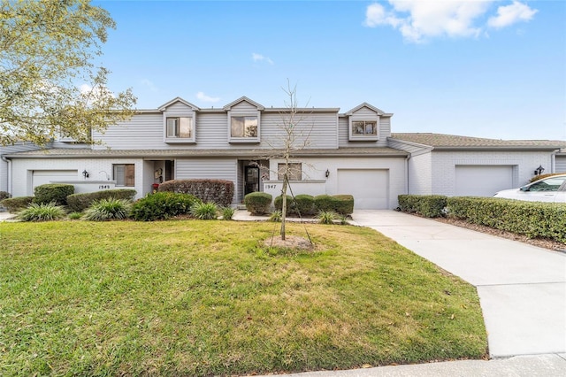 traditional-style home featuring a front yard, concrete driveway, brick siding, and an attached garage