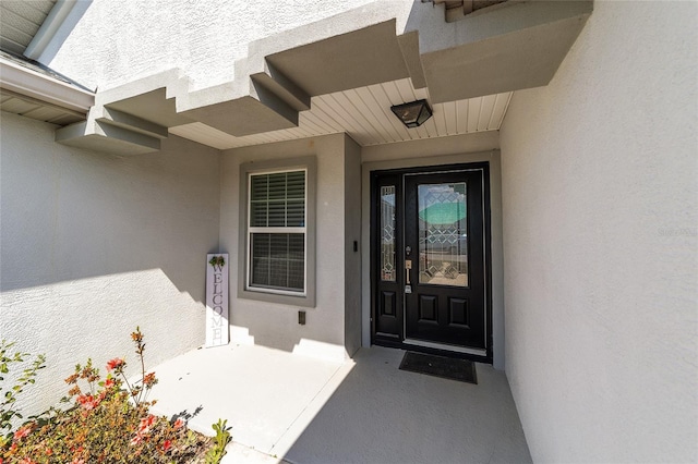 entrance to property with stucco siding