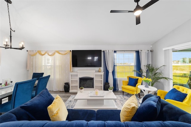 living area with wood finished floors, a glass covered fireplace, and a wealth of natural light