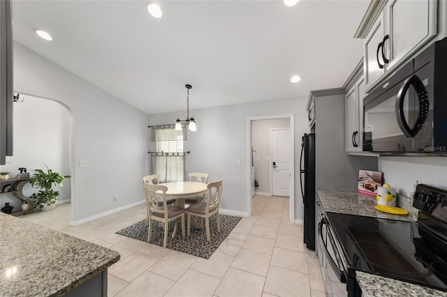 dining area featuring light tile patterned floors, baseboards, arched walkways, and vaulted ceiling