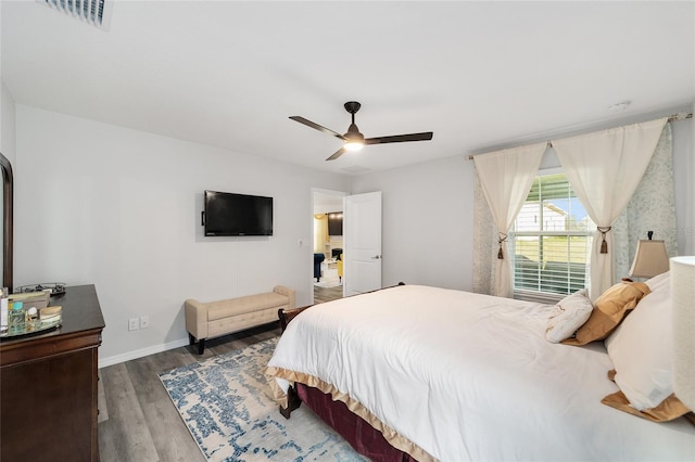 bedroom featuring a ceiling fan, baseboards, visible vents, and wood finished floors