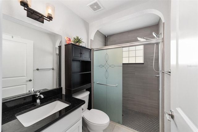 bathroom with toilet, a stall shower, vanity, and visible vents