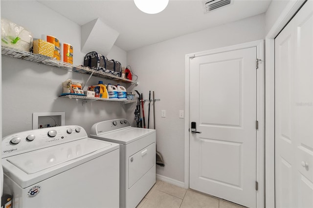 washroom with laundry area, light tile patterned floors, visible vents, baseboards, and washing machine and dryer