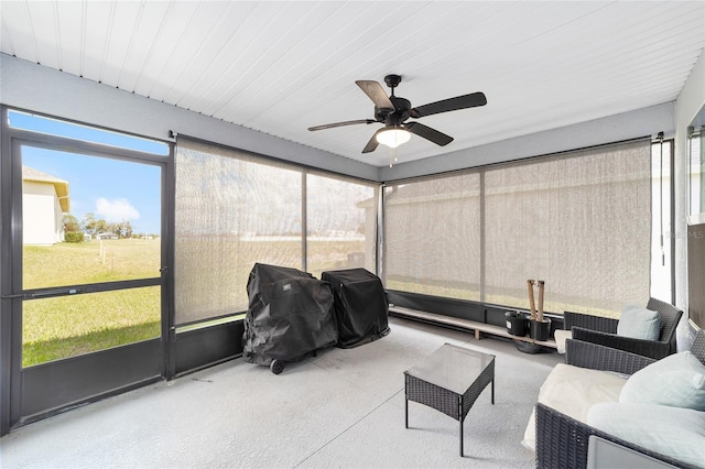 sunroom featuring a ceiling fan and plenty of natural light