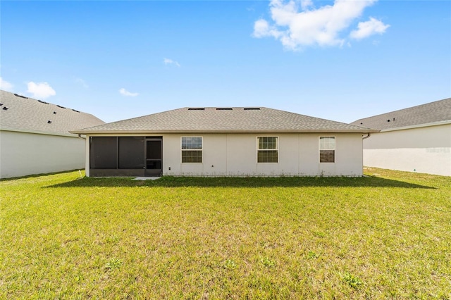 rear view of property featuring a sunroom and a yard