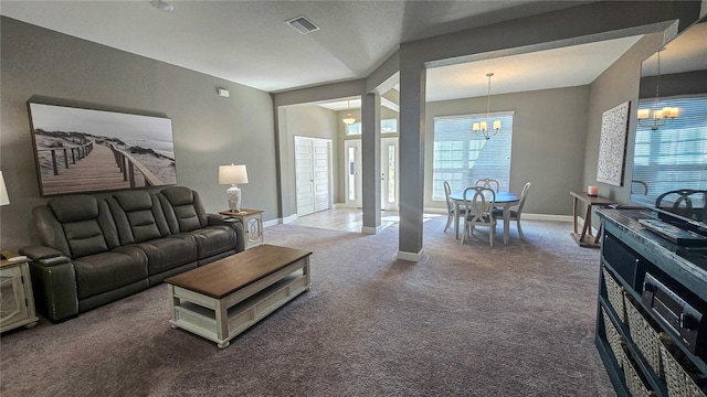 living area featuring carpet, visible vents, a notable chandelier, and baseboards