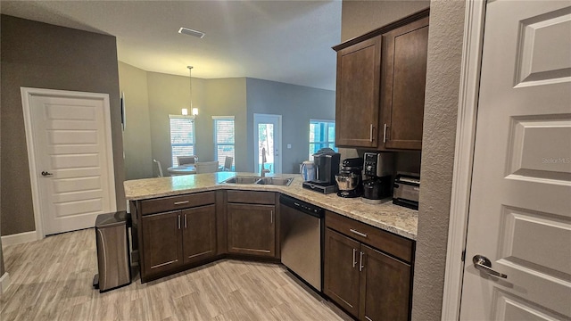 kitchen with a sink, light stone countertops, dishwasher, and hanging light fixtures