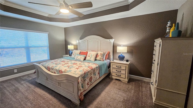 bedroom with ornamental molding, a raised ceiling, dark carpet, and baseboards