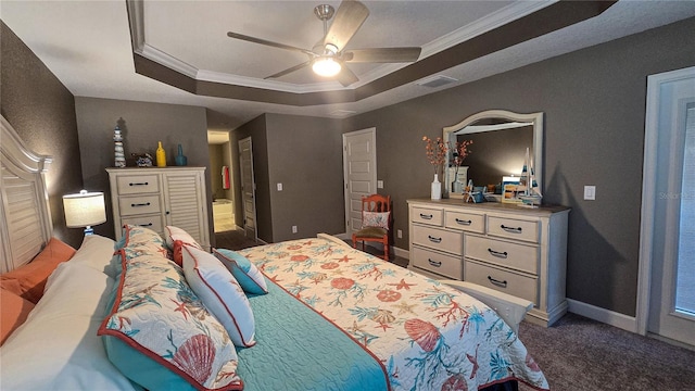 bedroom with a tray ceiling, crown molding, dark carpet, ceiling fan, and baseboards