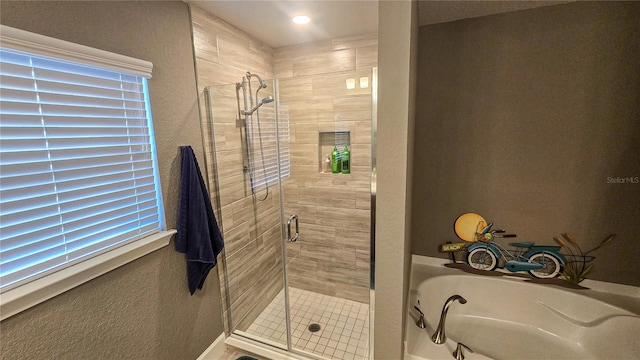 bathroom with a shower stall and a textured wall