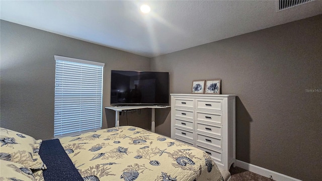 bedroom featuring baseboards and visible vents