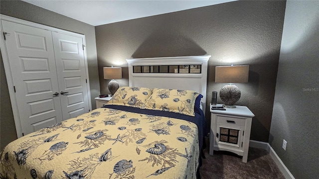 bedroom with baseboards, dark carpet, and a closet