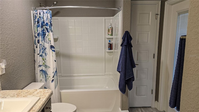 full bathroom with toilet, vanity, shower / tub combo with curtain, and a textured wall