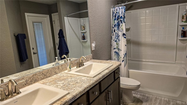 full bathroom featuring a textured wall, shower / tub combo, a sink, and double vanity