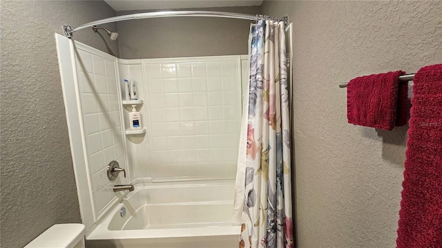 full bathroom featuring a textured wall and shower / tub combo