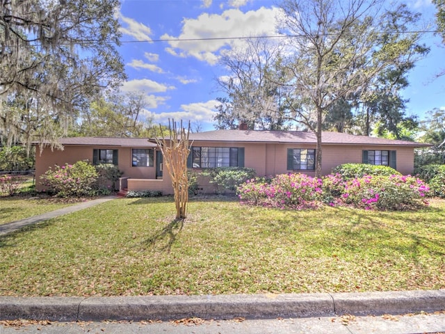 ranch-style home featuring a front lawn