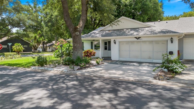 ranch-style house featuring an attached garage, concrete driveway, brick siding, and a shingled roof