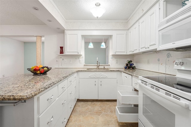 kitchen with white appliances, white cabinets, a peninsula, a sink, and backsplash