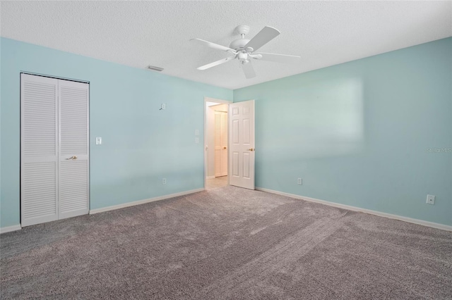 unfurnished bedroom with carpet, baseboards, and a textured ceiling