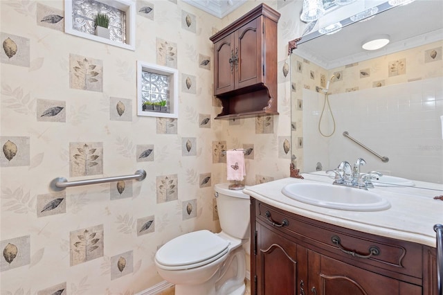 bathroom featuring toilet, wallpapered walls, a shower, and vanity