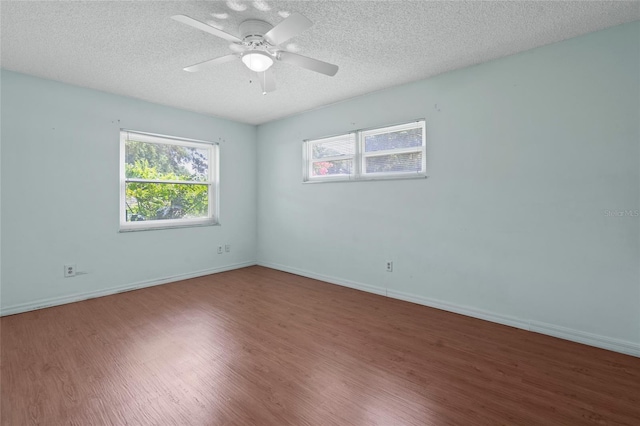 spare room with baseboards, a textured ceiling, a ceiling fan, and wood finished floors