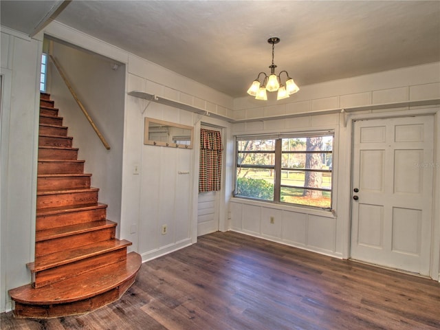 foyer featuring dark wood-type flooring, stairway, and a notable chandelier