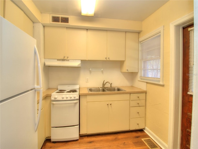 kitchen with white appliances, visible vents, light countertops, and a sink