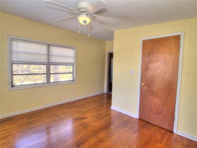 unfurnished bedroom with dark wood-style floors, baseboards, and a ceiling fan