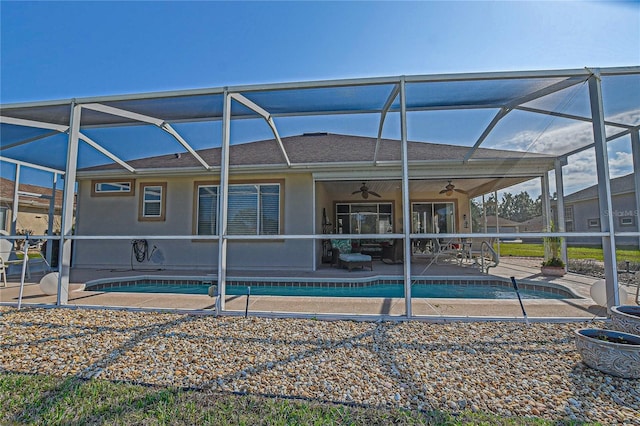 exterior space featuring a shingled roof, an outdoor pool, a ceiling fan, a patio area, and stucco siding