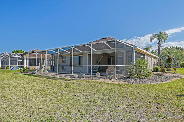 rear view of property with a yard and glass enclosure