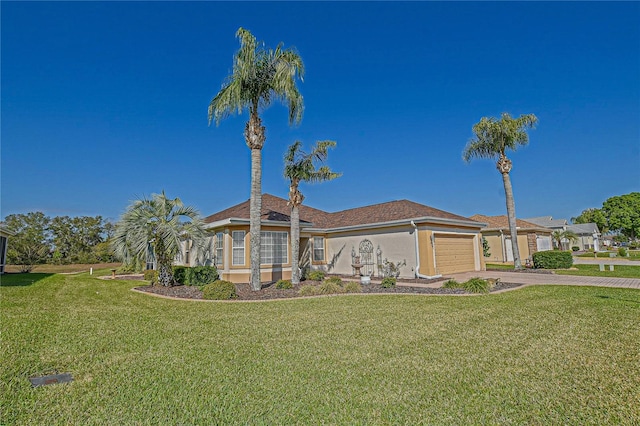 view of front of home with an attached garage, driveway, a front lawn, and stucco siding