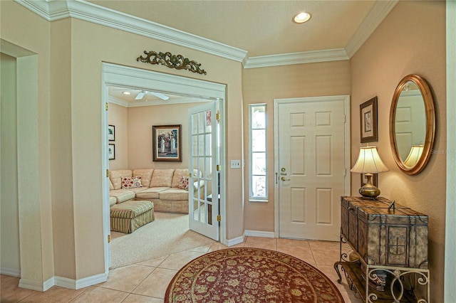 foyer featuring light tile patterned floors, baseboards, and ornamental molding