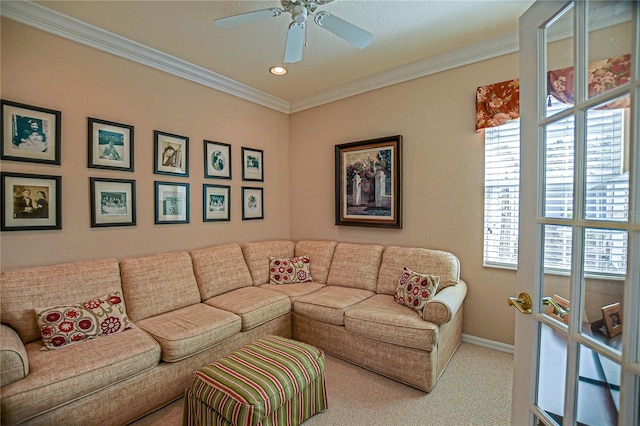 carpeted living room featuring ceiling fan, ornamental molding, and baseboards